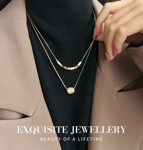 Dubbellaagse gouden ketting met vierkante kralen en een pavé cilinderhanger