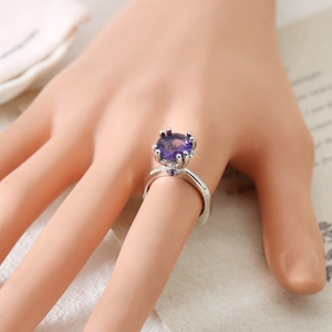 Anillo de plata elegante con una gran gema púrpura redonda y piedras laterales brillantes