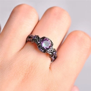 Gothischer Ring in Schwarz mit rundem lila Zirkon und Hohlmuster an der Modellhand