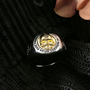 Vintage two-tone skull ring with engraved motivational text on black lace background