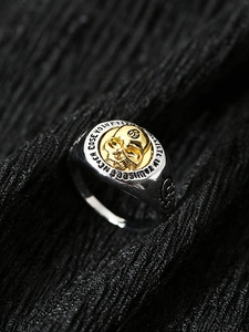Macro detail of gothic skull ring featuring two-tone metal finish and side engravings