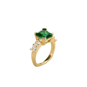 Detail van smaragdgroene zirkoon ring met baguette zijstenen op gouden band