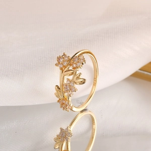 Gold-plated S925 silver flower and leaf ring with zircon accents on white silk