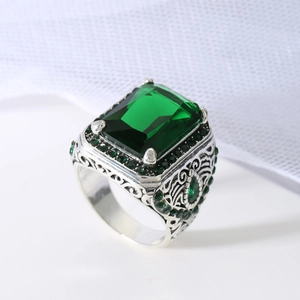 Vintage silver-tone ring with emerald-cut green gemstone and intricate hollow carving