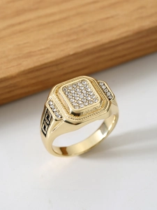 Detailansicht eines goldenen quadratischen Rings mit Kristallinlay und griechischem Muster