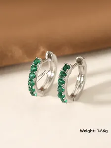 Detail view of silver zircon earrings with 10mm inner diameter and green stones