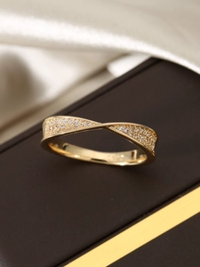 Macro shot of 18k gold plated S925 silver twist ring with shimmering pave zircons