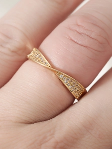 Macro shot of 18k gold plated twist ring with micro-paved zircons on a model's finger