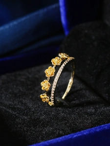 Detailansicht eines doppellagigen Goldrings mit Rosenmotiven und Zirkonia-Pflastersteinen