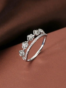 Detail eines zweischichtigen Rings mit zarten Rosenmotiven und weißen Zirkoniasteinen