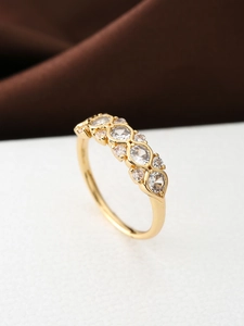 Detailaufnahme eines Goldrings mit sieben funkelnden Zirkonia in Marquise-Fassung