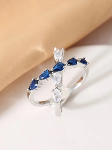 Detailed close-up of a silver ring featuring blue and white pear-cut gemstones