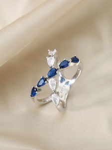 Detail of cross teardrop ring with alternating blue and white pear-cut cubic zirconia