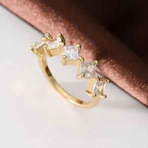 Elegant gold-plated ring with five square-cut zircons in a minimalist prong setting