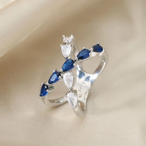 Crossed S925 silver ring with blue and white pear-cut stones on champagne silk