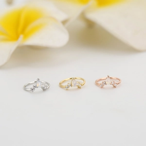 Dettaglio di tre anelli da naso con zirconi colorati in argento, oro e oro rosa lucido