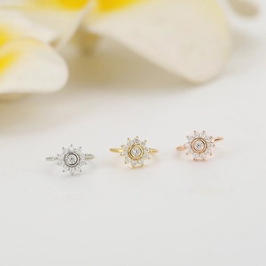 Dettaglio dei piercing al naso a forma di margherita in argento, oro e oro rosa
