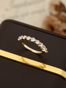 Macro detail of gold eternity ring with nine round diamonds set on a jewelry box