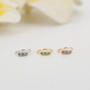 Vista macro di anelli in argento, oro e oro rosa con pietre di zircone colorate