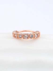 Dettaglio di un anello in oro rosa con zirconi cubici quadrati e rotondi alternati