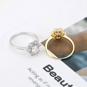 Eleganti anelli halo girasole in oro e argento con zirconi brillanti su una rivista