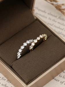 Macro detail of gold and silver pave set zircon hoop earrings on velvet display