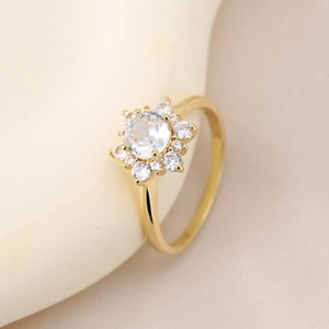 Dettaglio dell'anello a forma di girasole dorato con castone di zirconi scintillanti