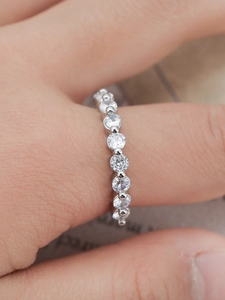 Macro detail of elegant silver eternity ring with sparkling cubic zirconia on finger