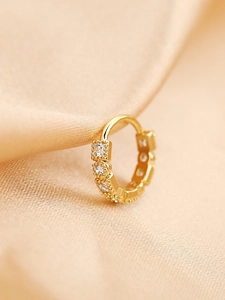 Dettaglio di un anello da naso placcato oro con quattro zirconi quadrati e bordi a microsfere