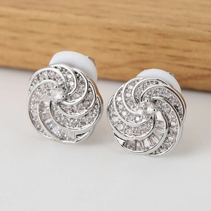 Macro detail of silver flower earrings with zircon pavé and soft silicone backings