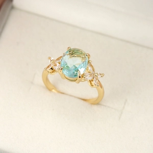Elegante anello placcato oro 18 carati con gemma blu ovale e accenti in zircone