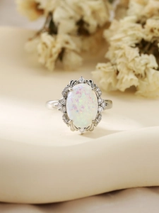 Macro view of vintage silver ring with oval white opal and halo of white zircons