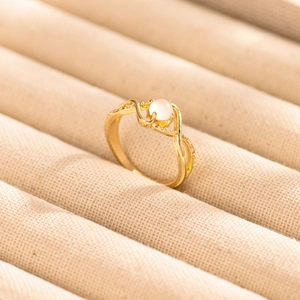 Elegant gold-plated ring with round moonstone and twisted diamond-encrusted band