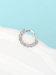 Dettaglio di un anello da naso argento con nove pietre di zircone cubico incastonate a griffe