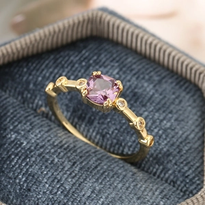 Macro shot of square purple gemstone ring with gold plating and sparkling small diamonds