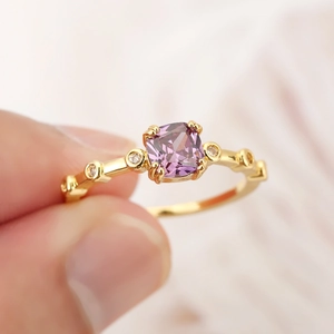 Elegant gold ring with cushion-cut purple crystal and sparkling side stones