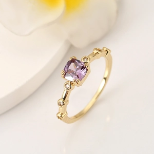 Macro view of a square purple gemstone ring with gold plating and cubic zirconia accents