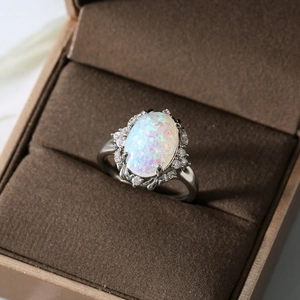 Elegant silver ring featuring a large oval opal center stone with halo zircon accents
