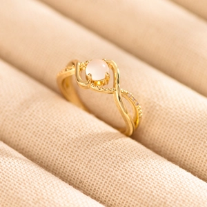 Macro shot of minimalist gold ring with moonstone main gem and paved side diamonds