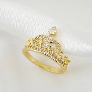 Elegant 18K gold-plated crown ring featuring sparkling cubic zirconia on white silk cloth
