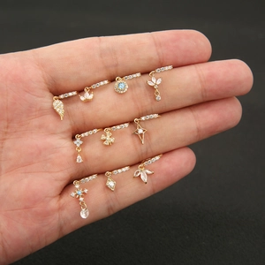 Makro-Ansicht von 10 vergoldeten Mini-Hoops mit Zirkonia-Anhängern wie Evil Eye und Krone