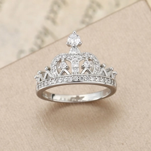Elegant silver crown ring with brilliant cubic zirconia stones on textured background