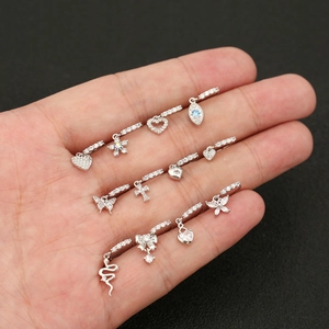 Silver earring set with star heart and zircon pendants shown on hand model