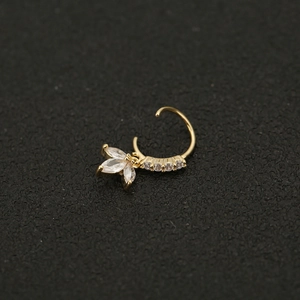 Detailansicht goldener Nasenring mit Blumenmuster und Zirkonia auf dunklem Hintergrund