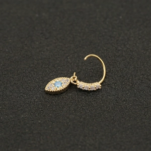 Macro shot of evil eye nose ring with blue crystal and pavé white zircons in gold finish