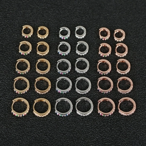 Set of 15 pairs of gold, silver, and rose gold huggie earrings with rainbow and white cubic zirconia