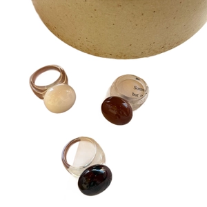 Bagues minimalistes en résine ivoire et caramel avec design cabochon sur fond blanc épuré