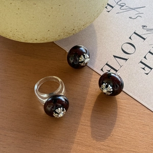 Detailansicht von Harzring und Ohrring-Set mit Schildpattkugel und silbernem Kreuzmuster