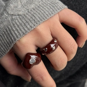 Detailed view of chocolate brown enamel rings with silver heart stud and clear crystal