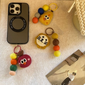Detailed close-up of handmade felt cartoon charms with colorful wool bead chain and phone case